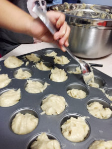 A kid making gluten free vegan banana muffins